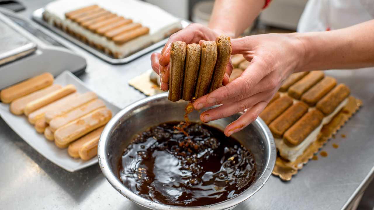 Ragazza intenta a preparare un gustoso tiramisù in cucina - foto Depositphotos - Solofinanza.it